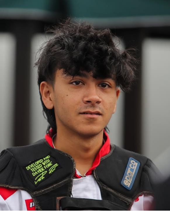 Aarogya Dahal in racing suit in the paddock