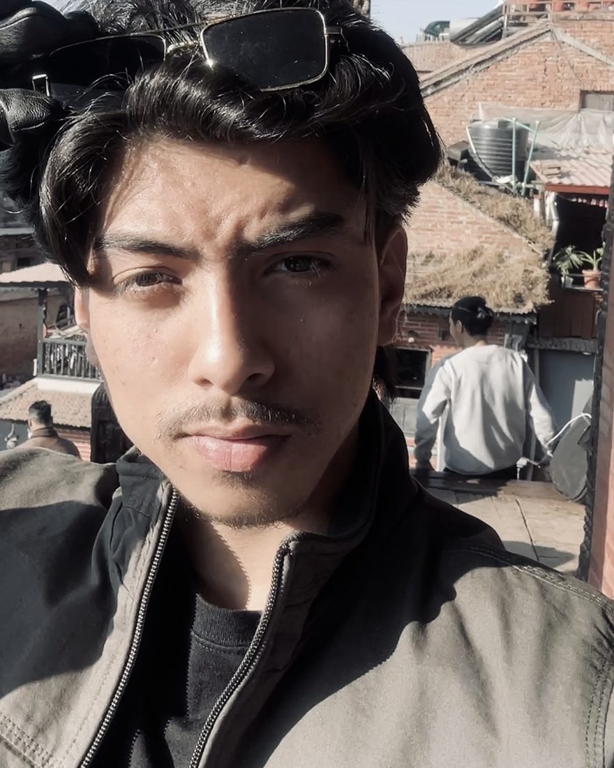 Narayan Chhetri photographed beneath a carved temple strut